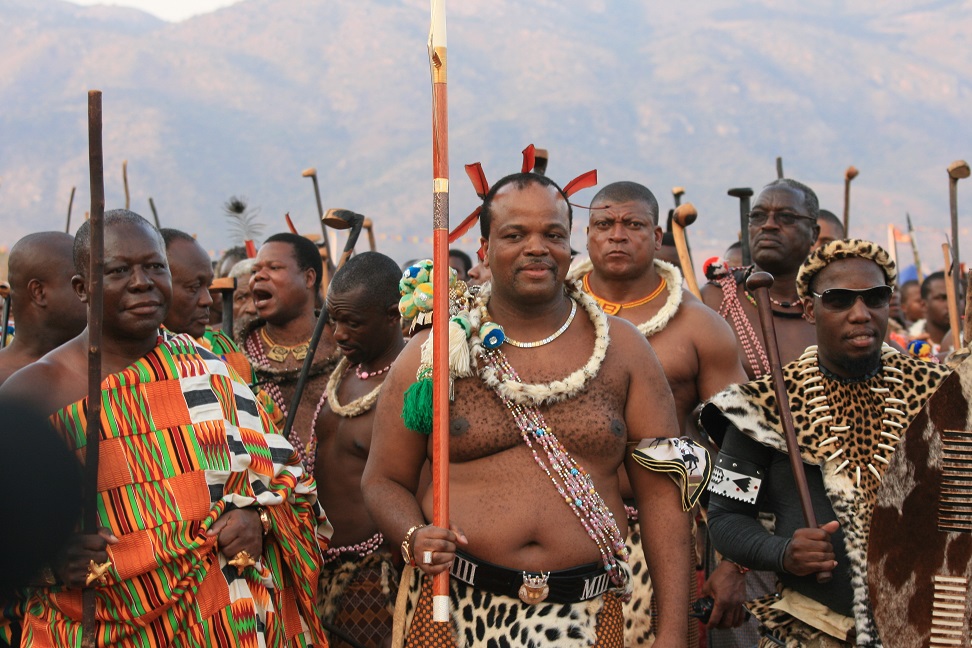 King Mswati III (C) flanked by his entrourage and security guards watches the rehearsals for the Umhlanga dance in Ludzidzini, Swaziland, 30 August 2015. The traditional Umhlanga or Reed dance, in which thousands of young women dance for the Queen Mother and King Mswati III is the cultural highlight of the year in Swaziland and takes place on 31 August. Photo: Juergen Baetz/dpa